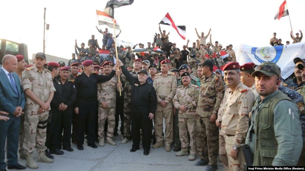 Iraqi Prime Minister Haidar al-Abadi holds an Iraqi flag as he declares victory over IS in Mosul on July 10.