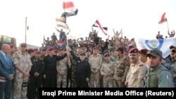 Хайдар аль-Абаді з прапором Іраку вітає з перемогою, 10 липня 2017 року, офіційне фото апарату прем’єра