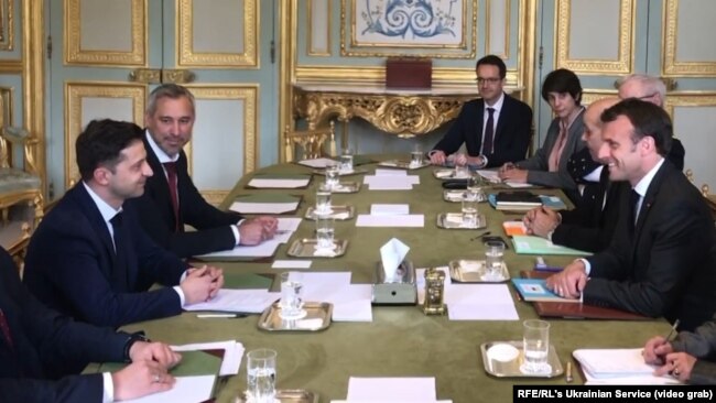 French President Emmanuel Macron (right) and Ukrainian presidential candidate Volodymyr Zelenskiy hold talks in Paris on April 12.