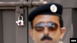 A Pakistani security official stands guard outside the office of the sealed international charity 'Save the Children' in Islamabad on June 12.