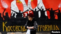 Женщина идет по улице в городе Косовска-Митровица на севере Косово.