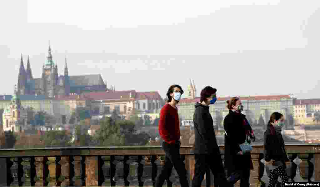 Прага, Чехія.&nbsp;Люди у захисних масках прогулюються вулицями міста. В країні також запровадили низку жорстких обмежувальних заходів для запобігання поширенню коронавірусної хвороби. Також уряд рекомендував роботодавцям заохочувати працівників працювати дистанційно та обмежувати особисті робочі контакти