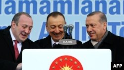 Gürcüstan prezidenti Giorgi Margvelashvili (solda), Azırbaycan prezidenti İlham Əliyev (mərkəzdə) və Türkiyə prezidenti Recep Tayyip Erdogan Qarsda TANAP layihəsinin imzalanması mərzisimi zamanı Heydər Əliyevin adını daşıyan məktəbin də açılışını edirlər. 17 mart 2015