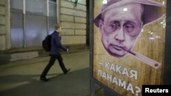 A man walks past a poster depicting Russian President Vladimir Putin and reading "Which Panama?" at a bus stop in Moscow on April 6.