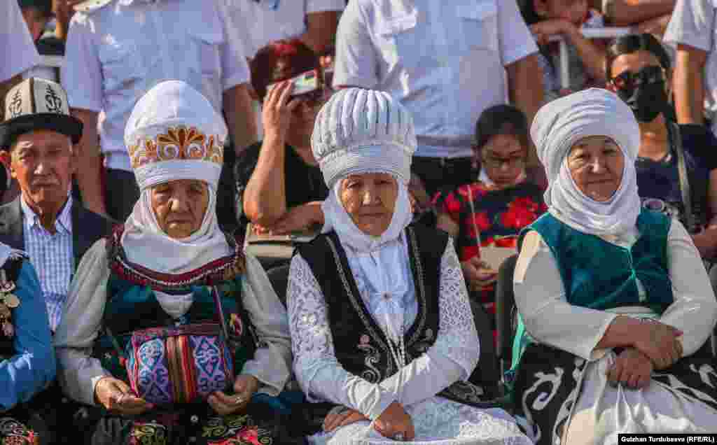 Женщины в национальных костюмах наблюдают за церемонией, посвященной 30-летию провозглашения независимости Кыргызстана от Советского Союза