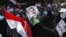 Supporters of the Muslim Brotherhood and ousted Egyptian President Muhammad Morsi hold his picture as they march toward Cairo University to demand his reinstatement on July 19.