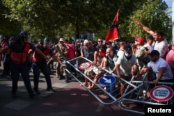 Demonstruesit mbajnë një pengesë ndërsa përleshen me policinë gjatë një demonstrate kundër qeverisë, në Tiranë, Shqipëri, 23 korrik 2026.