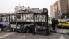 O fotografie arată epava unui autobuz ars, purtând un banner pe care scrie „Acesta a fost unul dintre noile autobuze ale Teheranului, plătit din banii taxelor cetățenilor”, în Piața Sadeqieh din Teheran, pe 15 ianuarie.