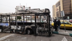 Na fotografiji se vidi olupina izgorjelog autobusa s transparentom na kojem piše: "Ovo je bio jedan od novih autobusa u Teheranu, plaćen novcem iz poreza građana", na trgu Sadeqieh u Teheranu, 15. januara.