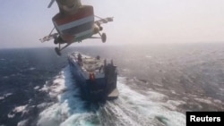 Военный вертолёт хуситов за несколько секунд до высадки пиратов на палубу грузового судна Galaxy Leader в Красном море. Стоп-кадр из пропагандистского видео, снятого самими пиратами во время захвата судна 19 ноября 2023) 