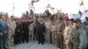 Iraqi Prime Minister Haidar al-Abadi holds an Iraqi flag as he declares victory over IS in Mosul on July 10.