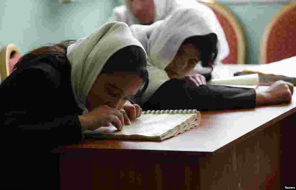 Visually impaired students read Braille during a lesson at the school.