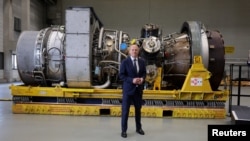 German Chancellor Olaf Scholz stands next to a gas turbine slated to be transported to the compressor station of the Nord Stream 1 gas pipeline in Russia during his visit to Siemens Energy's site in Muelheim an der Ruhr, Germany, on August 3.