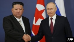Russian President Vladimir Putin (right) and North Korean leader Kim Jong Un shake hands during their meeting at the Vostochny Cosmodrome in Russia's Amur region on September 13.
