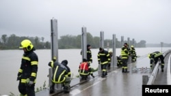 Vatrogasci sastavljaju barijeru pored Dunava kako bi spriječili izlijevanje rijeke na ulice u Mauthausenu, Austrija, 14. 9. 2024.