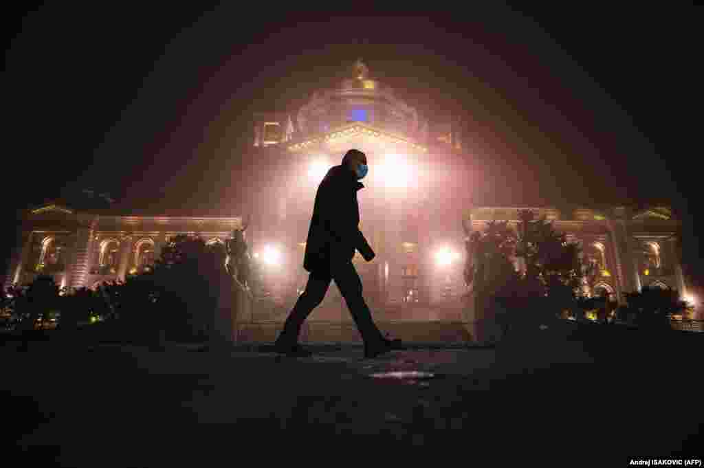 A man walks past the National Assembly building in Belgrade as heavy fog and air pollution dominate the sky over the Serbian capital. According to the AirVisual app, Belgrade has several times in the last week been among the most polluted cities in the world. (AFP/Andrej Isakovic)