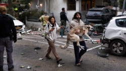 Israel -- A man carries a dog to a shelter as sirens sound