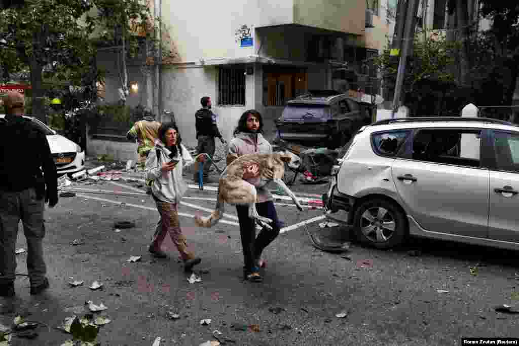 A man carries a dog toward a shelter in Tel Aviv as sirens sound after Iran launched missiles at Israel on April 1.