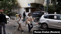 یک مرد در حال انتقال سگش به پناهگاه در اسرائیل به دلیل حملات موشکی جمهوری اسلامی ایران