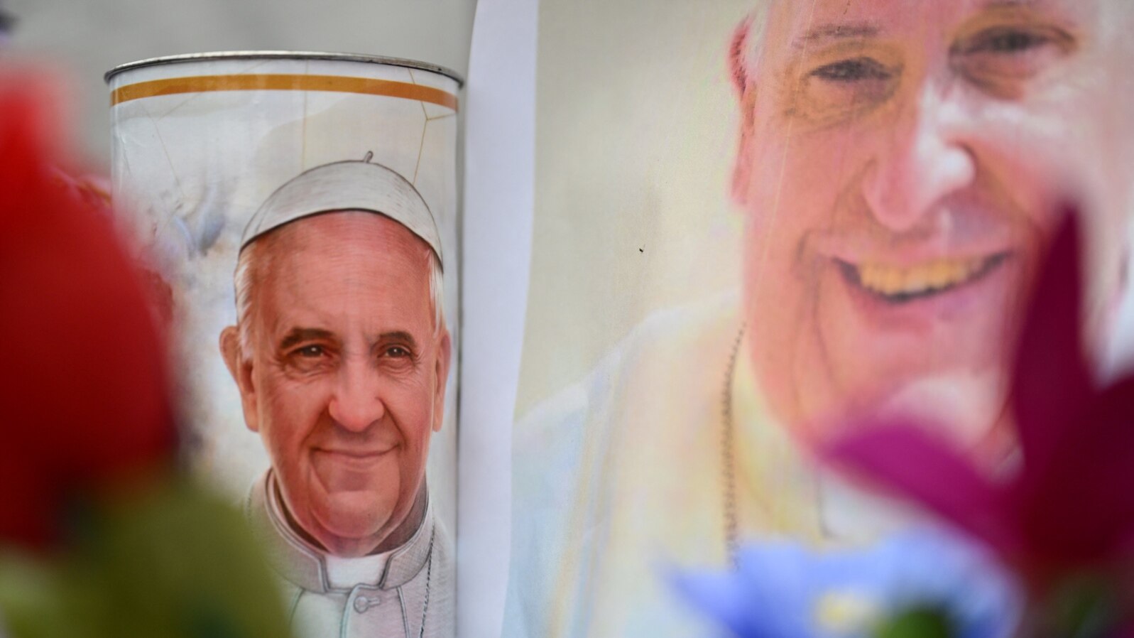 Flowers and portraits of Pope Francis are laid at the statue of John Paul II outside the Gemelli hospital where Pope Francis is hospitalized, in Rome on February 24, 2025.