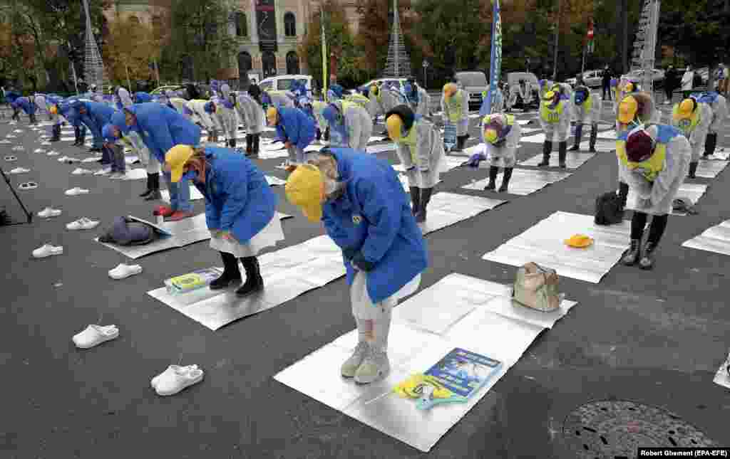 Romanian health-care workers protest on thermal blankets against working conditions during the coronavirus pandemic in Bucharest. (epa-EFE/Robert Ghement)