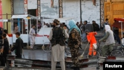 Талибански борци чуваат стража на местото на експлозијата во Кабул, 6 август 2022 година