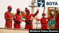 Punëtorë të kompanisë shtetërore të naftës PDVSA, duke mbajtur flamuj iranianë dhe venezuelianë, përshëndesnin gjatë mbërritjes së cisternës iraniane të naftës “Fortune” në rafinerinë El Palito, në Puerto Cabello, më 25 maj 2020.