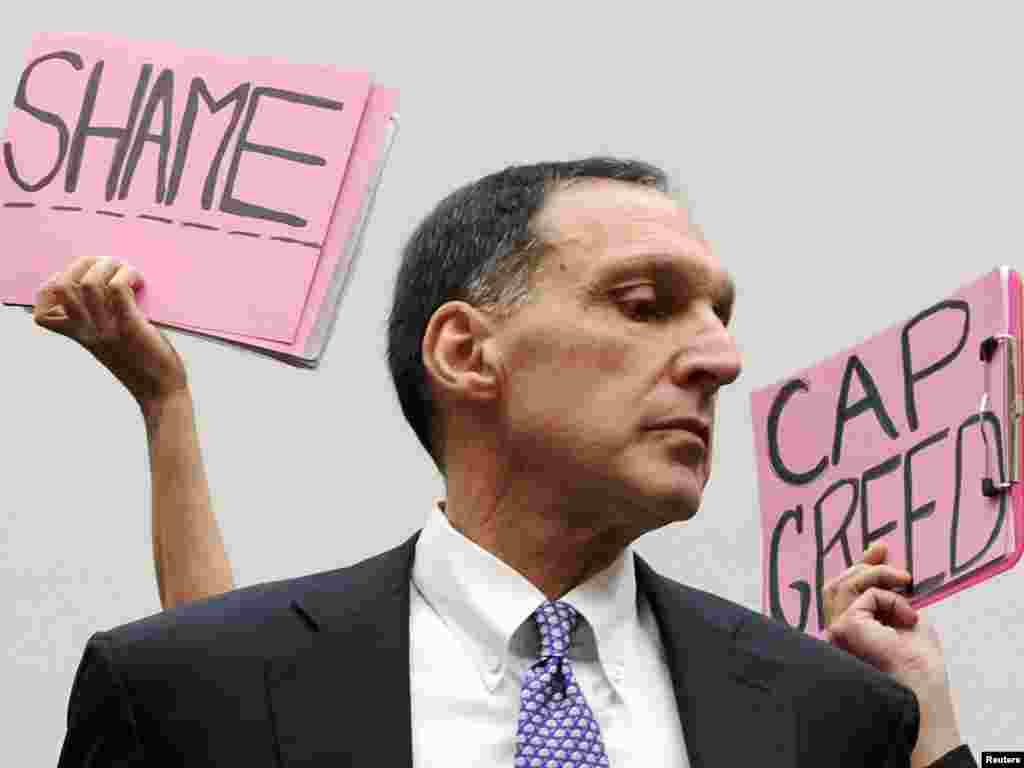 Protesters hold signs behind Richard Fuld, Chairman and Chief Executive of Lehman Brothers Holdings, as he takes his seat to testify at a House Oversight and Government Reform Committee hearing on the causes and effects of the Lehman Brothers bankruptcy, on Capitol Hill in Washington, October 6, 2008. Fuld told Congress on Monday that U.S. banking regulators knew exactly how Lehman was pricing its distressed assets and about its liquidity in the months before its collapse. REUTERS/Jonathan Ernst 