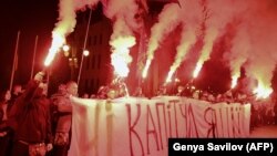 Ukrainian nationalists burn flares and hold a banner reading "No to capitulation" during their protest against the approval of so-called the Steinmeier Formula for elections in eastern Ukraine. 