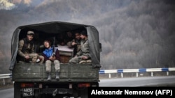 Ерменски војници седат во задниот дел на камион, 15 ноември 2020 година
