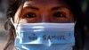 Участница акции протеста в Тулузе. Надпись на маске: "Я – Сэмюэль". Так звали убитого и обезглавленного французского учителя
