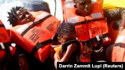 Migranti nakon što su spašeni iz malog drvenog čamca u međunarodnim vodama kod obale Libije, u zapadnom Sredozemnom moru.
