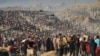 Palestinezë duke bartur thasë dhe pako me ushqime dhe ndihma tjera humanitare, që u shkarkuan nga një karvan kamionësh të Programit Botëror të Ushqimit, i cili po shkonte drejt Qytetit të Gazës, në veri të Rripit të Gazës, më 16 qershor 2025.