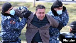 Armenia -- Riot police detain an anti-government protester in Yerevan, February 23, 2021.