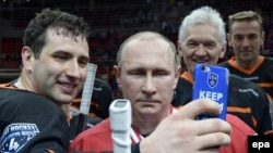 Obosiți, dar fericiți. Vladimir Putin și apropiați de-ai săi, după meciul Ligii nocturne de hochei de la Soci: Roman Rotenberg (stânga) și Ghennadi Timcenko (al doilea din dreapta). Mai 2015