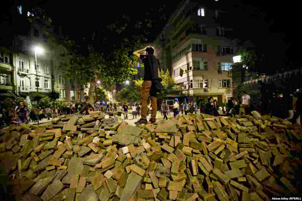 &nbsp;An antigovernment protester stands atop a homemade barricade near Taksim Square in Istanbul. (RFE/RL/Abbas Atilay)