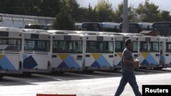 A man walks past buses that are not in operation due to a 24-hour strike in urban transport at a bus station in Helleniko, ,Greece