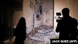 Jurnaliști filmează o locuință distrusă de o rachetă palestiniană în orășelul Sderot din sudul Israelului.