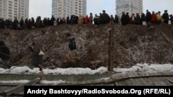 Кияни ламають паркан навколо забудови біля озера Тельбин, Київ, 3 січня 2013 року