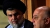 IRAQ -- Iraqi Shi'ite cleric Moqtada al-Sadr, who's bloc came first, looks at Iraqi Prime Minister Haider al-Abadi, who's political bloc came third in a May parliamentary election, during a news conference in Najaf, Iraq June 23, 2018. 