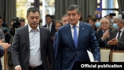 Prime Minister Sadyr Japarov (left) walks with ex-President Sooronbai Jeenbekov in Bishkek on October 16, the day after Japarov took over presidential powers.