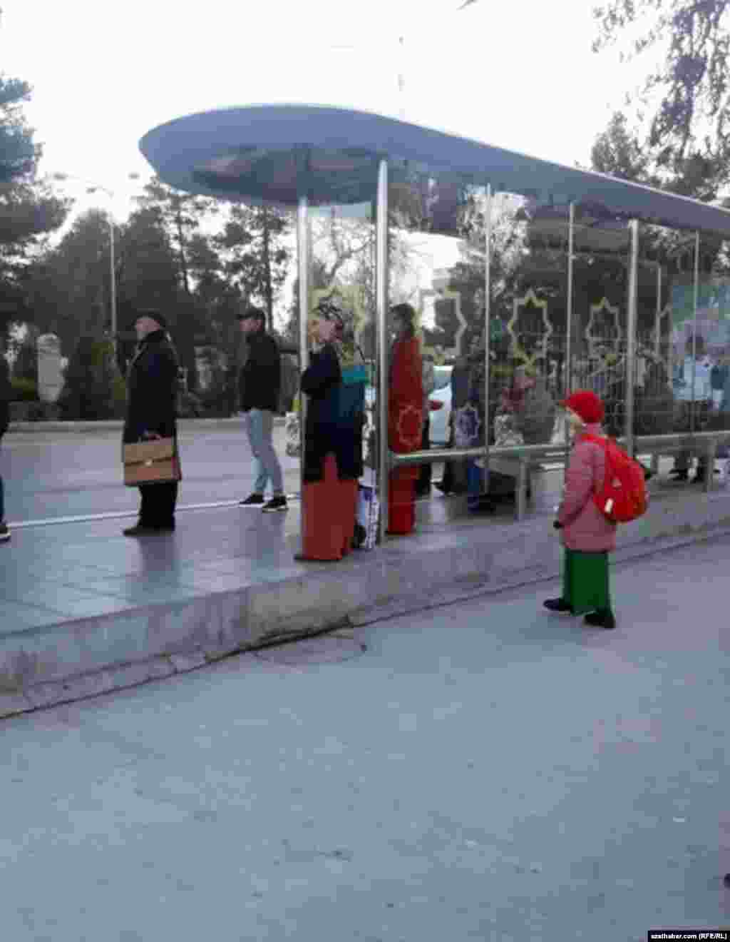 Duralgada awtobusa garaşyp duran adamlar