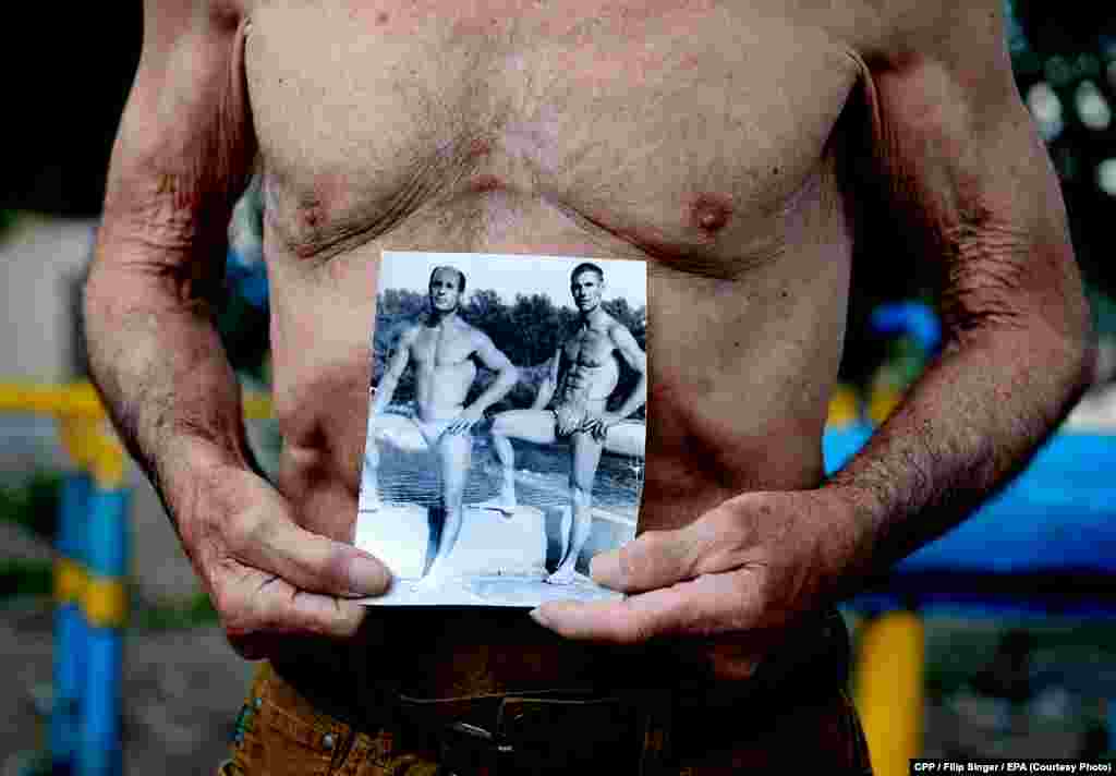 Second Prize, Sport: An 81-year-old former Soviet athlete shows an old picture of himself at the Kachalka outdoor fitness center in Kyiv, Ukraine. (epa/Filip Singer)