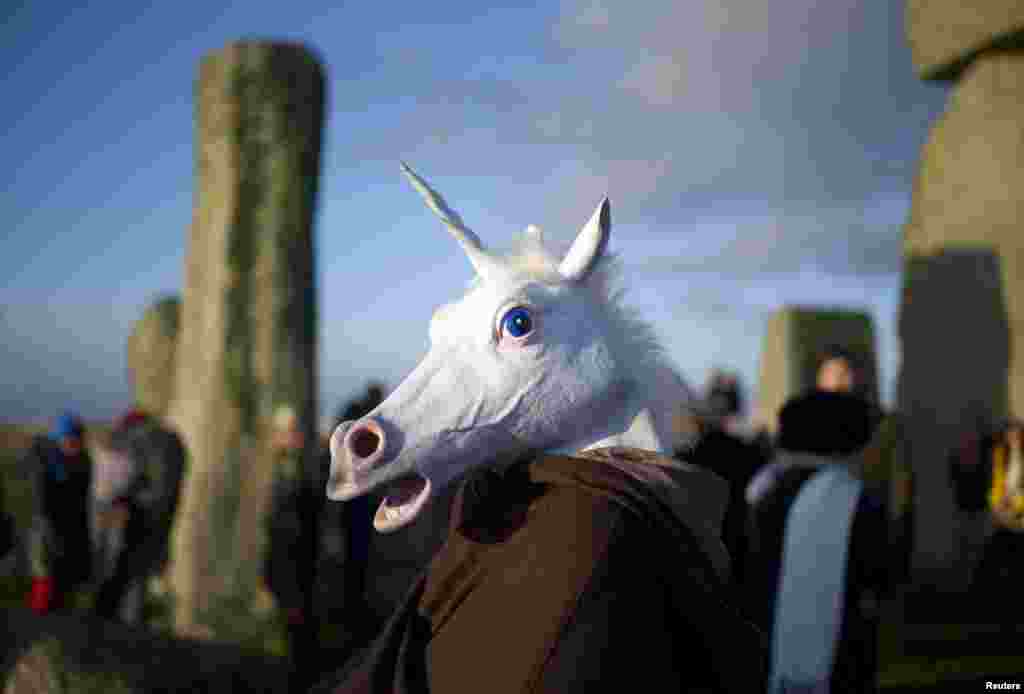 A reveler, dressed as a unicorn, celebrates the sunrise during the winter solstice at Stonehenge on Salisbury Plain in southern England. (Reuters/Kieran Doherty)