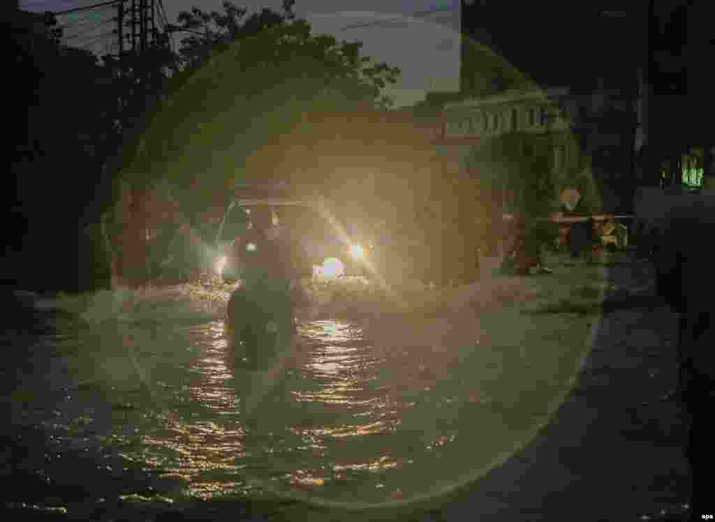 People make their way through a flooded road in Lahore.