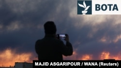 Një person xhiron tymin që ngrihet pas një shpërthimi, pasi Izraeli dhe Shtetet e Bashkuara nisën sulmet ajrore në Teheran më 3 mars.