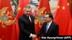 Li Ko-csiang kínai miniszterelnök és Milo Đukanović akkori montenegrói miniszterelnök (jelenleg államfő) kézfogása pekingi találkozójukon, 2015. november 26-án
