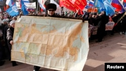 A man holds a map of the Soviet Union during a rally to support Russian-speakers living in Crimea and Ukraine, in the center of the Siberian city of Krasnoyarsk.