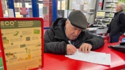 Un bărbat completează actele necesare pentru a beneficia de electrocasnice folosind ecovoucherul oferit de stat, martie 2025