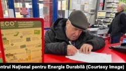 Un bărbat completează actele necesare pentru a beneficia de electrocasnice folosind ecovoucherul oferit de stat, martie 2025